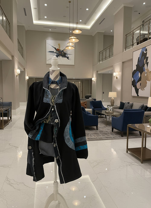 Black garment with blue and gray pattern on a mannequin against a checkered background