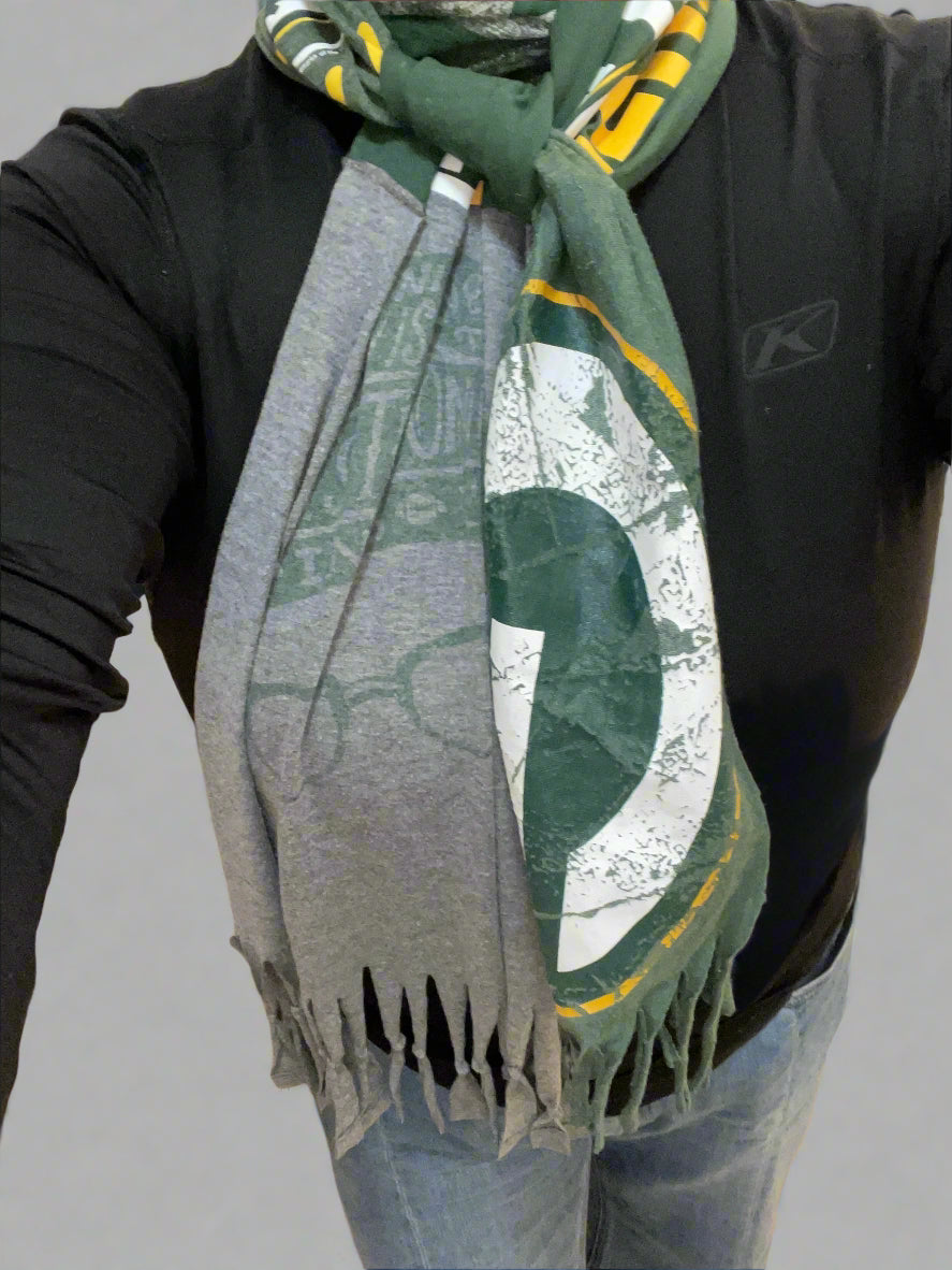 Person wearing a green and gray scarf with a logo, standing indoors.